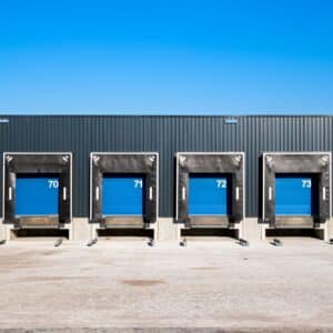 A picture of 4 loading dock doors of a warehouse.