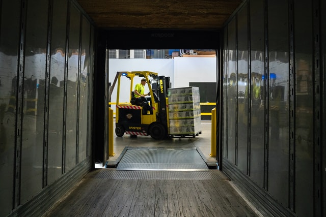 cold storage warehouse - a picture of a man on a forklift hauling a pallet