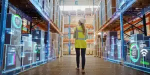 woman with computer in warehouse looking at automated solutions with AI