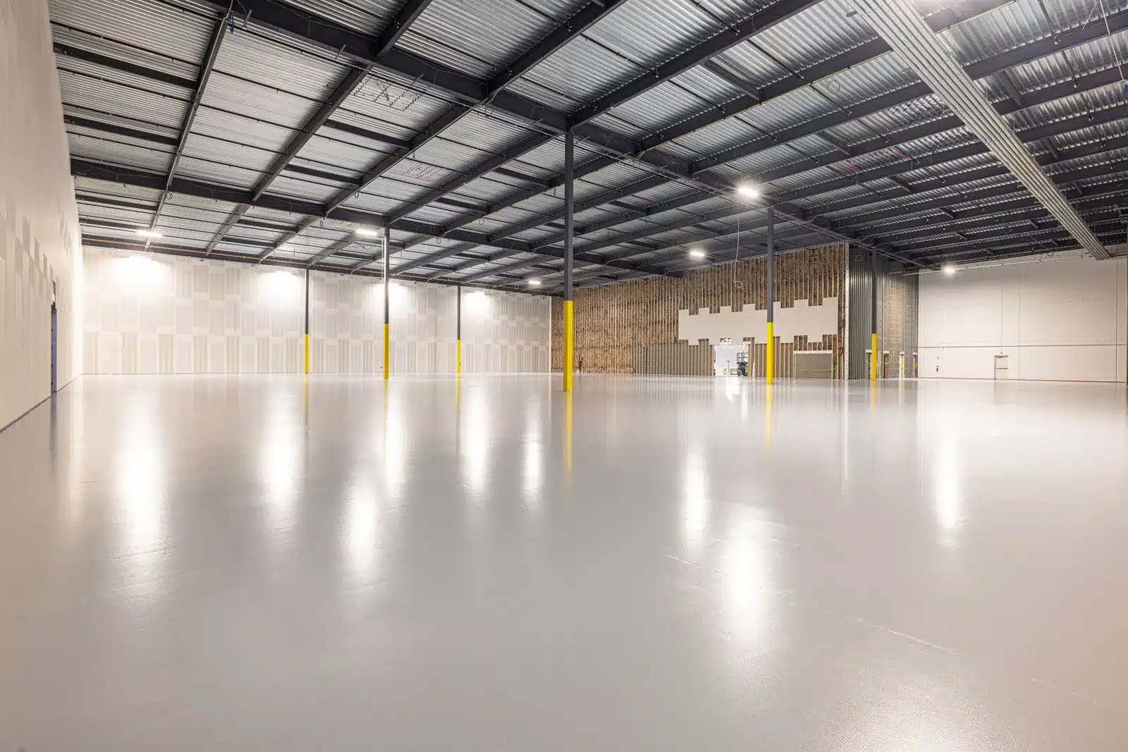 Empty modern warehouse floor with open bays and epoxy coating, showing available warehouse capacity ready to scale into on demand
